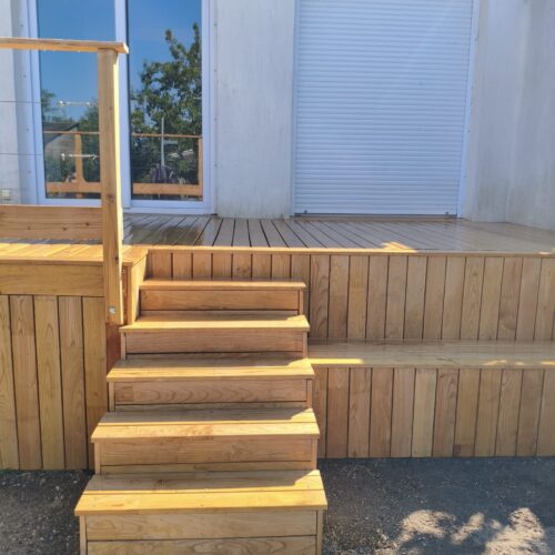 Escalier en châtaignier donnant accès à une terrasse sur pilotis